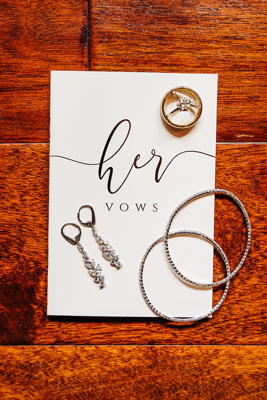 Detailed flatlay of rings, jewelry and vow book.