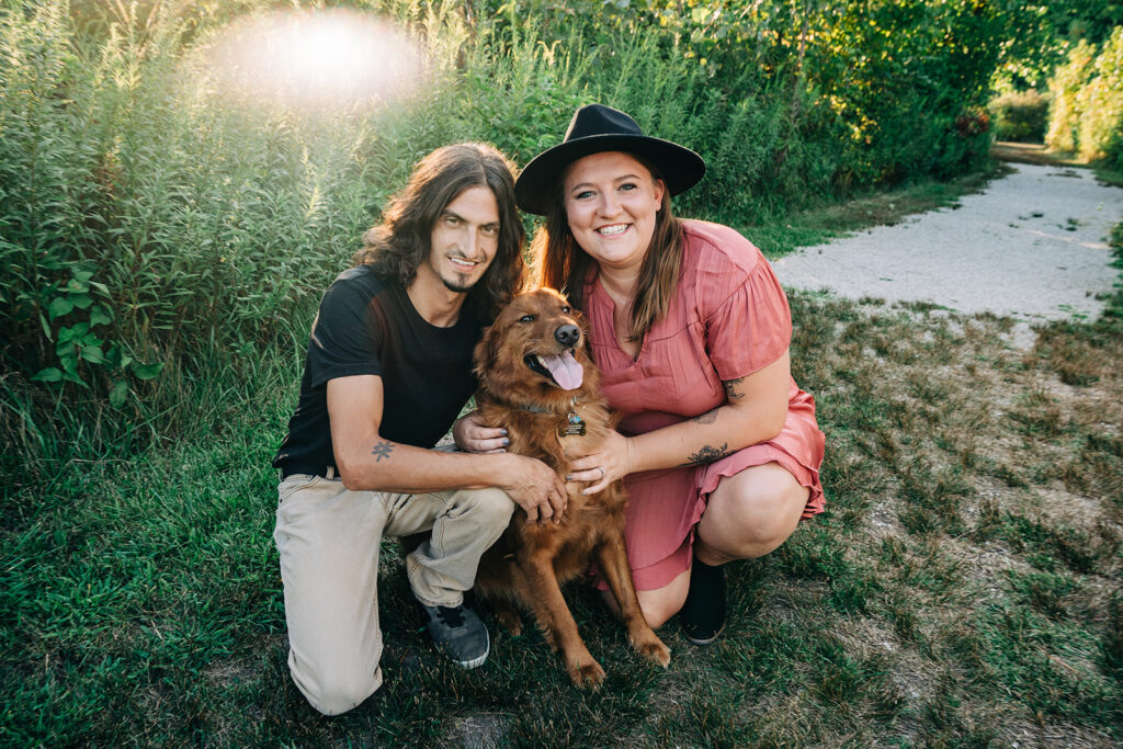 a couple poses with their pup at a park in Indianapolis 